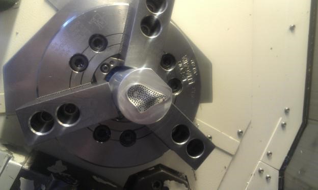 The machining assembly to cut the part in the 5-axis lathe
